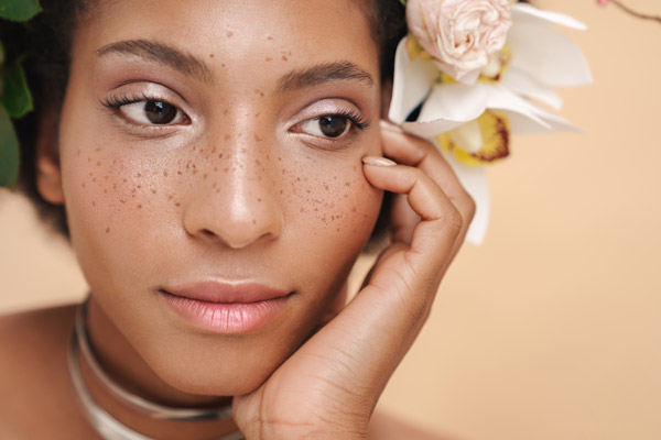 Pretty lady with freckles, natural skin and flowers in her hair