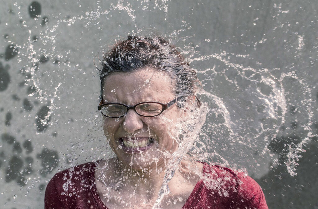 Woman with water being splashed on her face